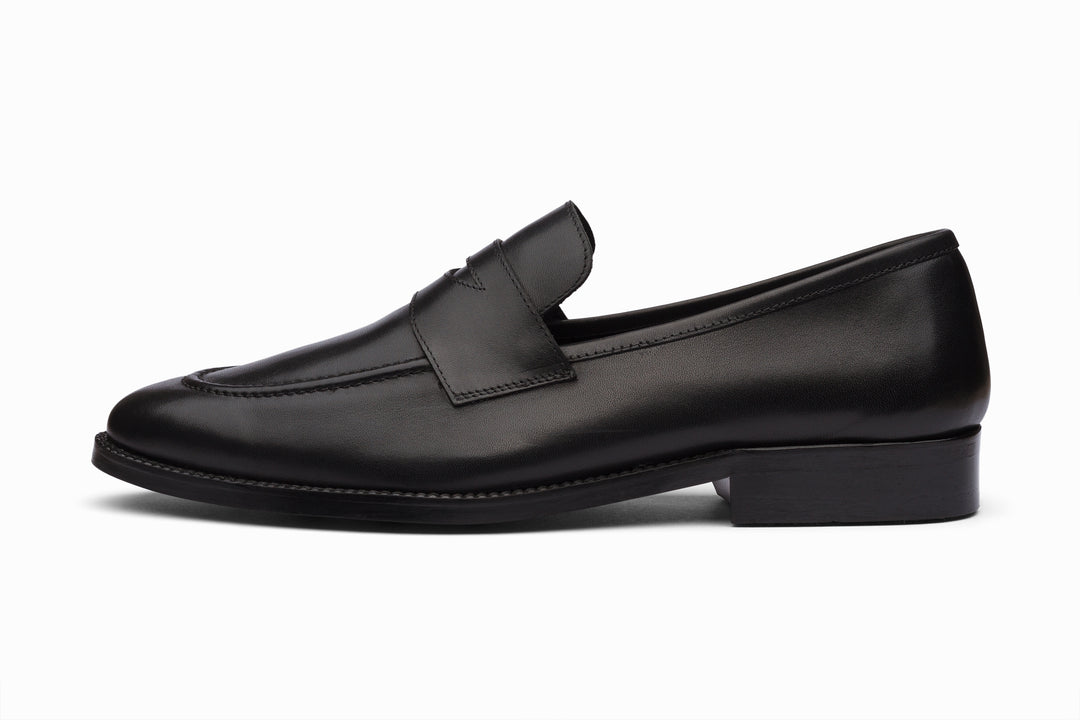 Black unlined penny loafer — side profile — soft calfskin, no break-in needed